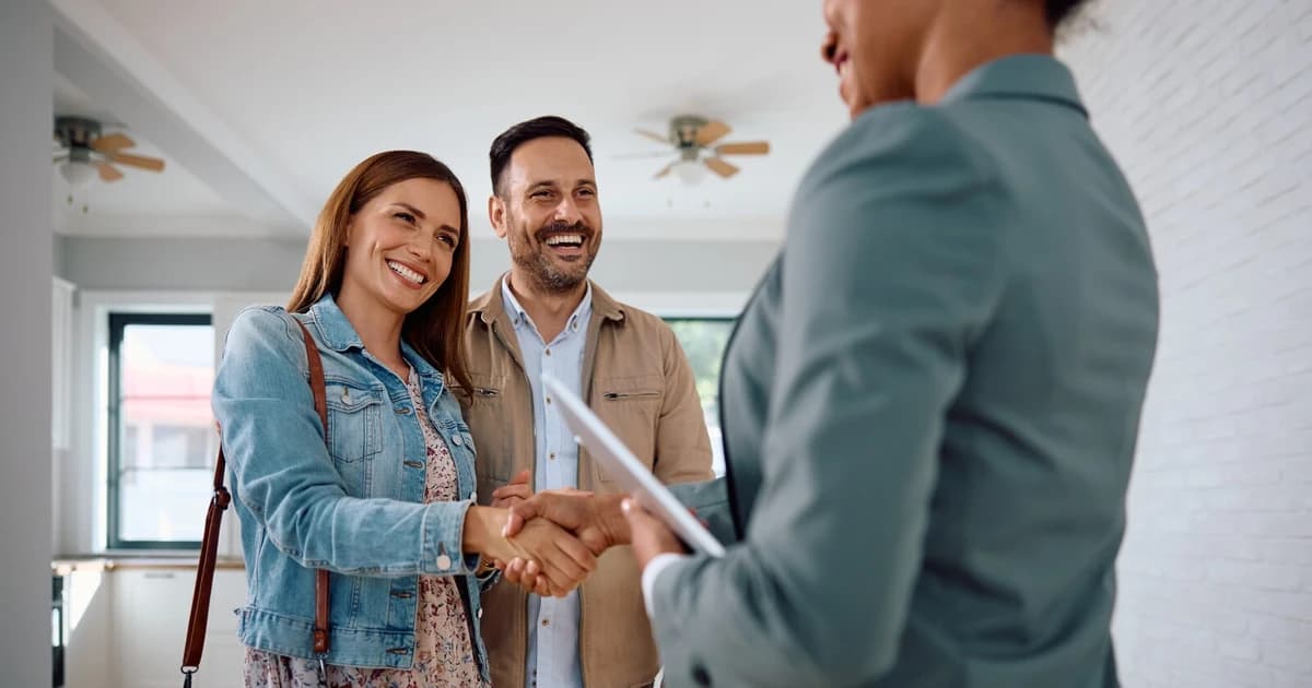 Real estate agent and investor clients shaking hands in a Pennsylvania home after reviewing a financing checklist